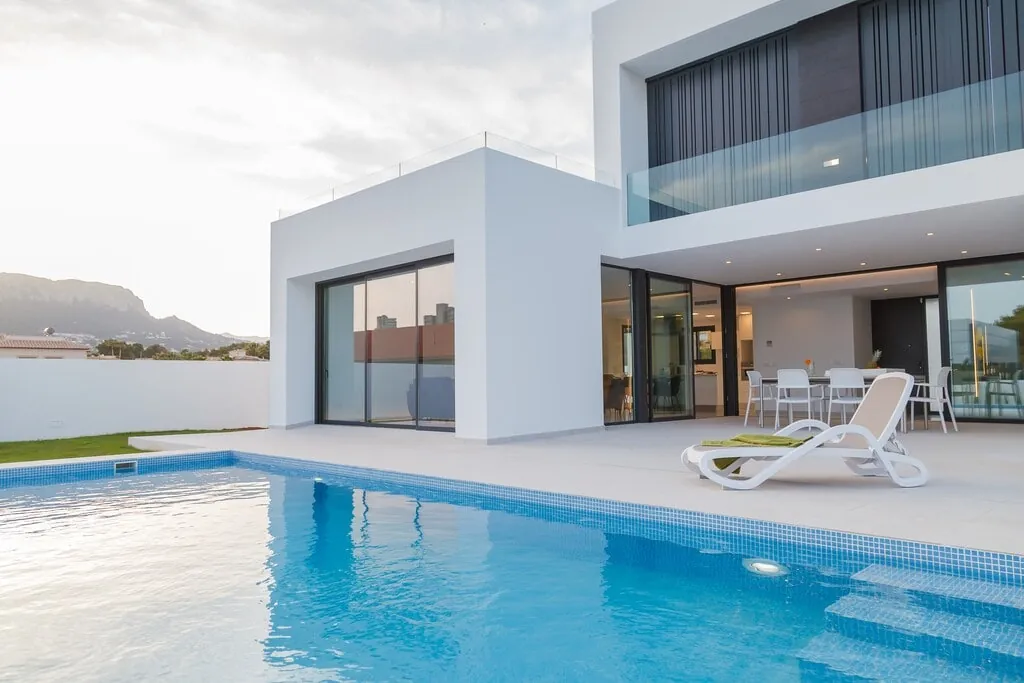 Der Pool der Länge nach, mit der überdachten Terrasse und dem Balkon darüber.